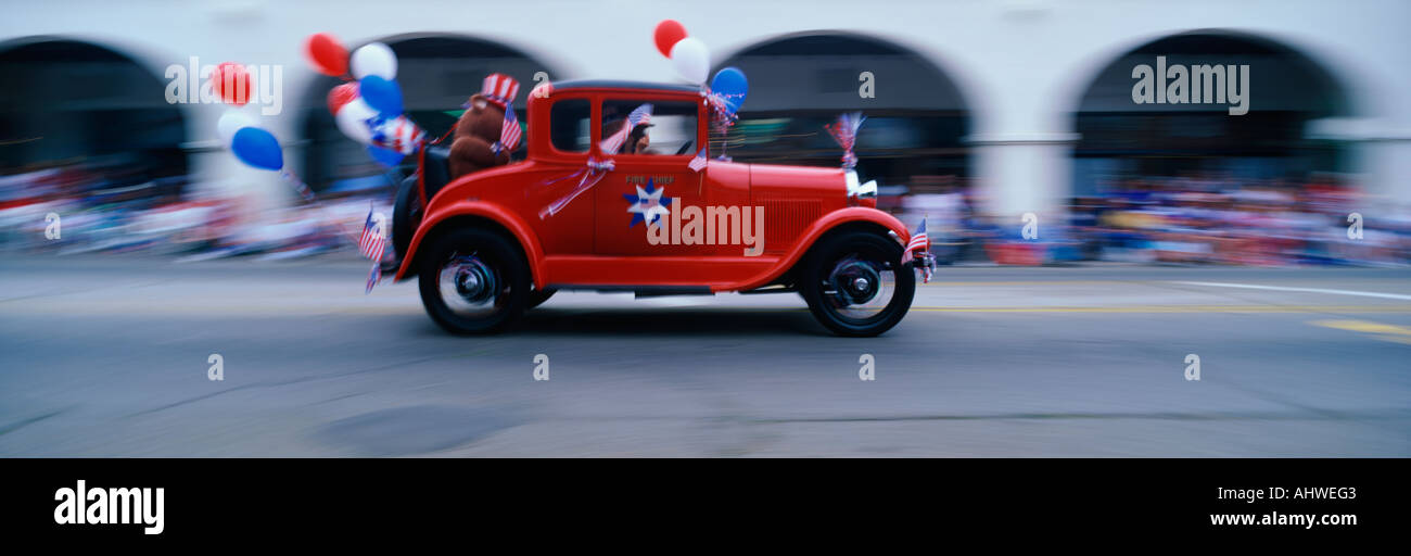 Il s'agit d'une indépendance Day Parade dans une petite ville, il montre de patriotisme et d'un morceau d'Americana Il y a une voiture rouge vintage que Banque D'Images