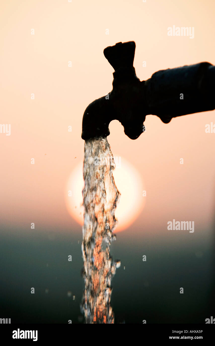 Tuyau de support qui se profile à l'aube du robinet avec de l'eau courante. L'Inde Banque D'Images