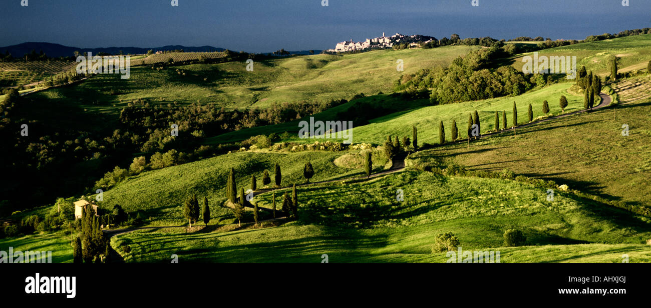 Route à travers le paysage de Toscane avec des cyprès et hill top ville, Italie Banque D'Images