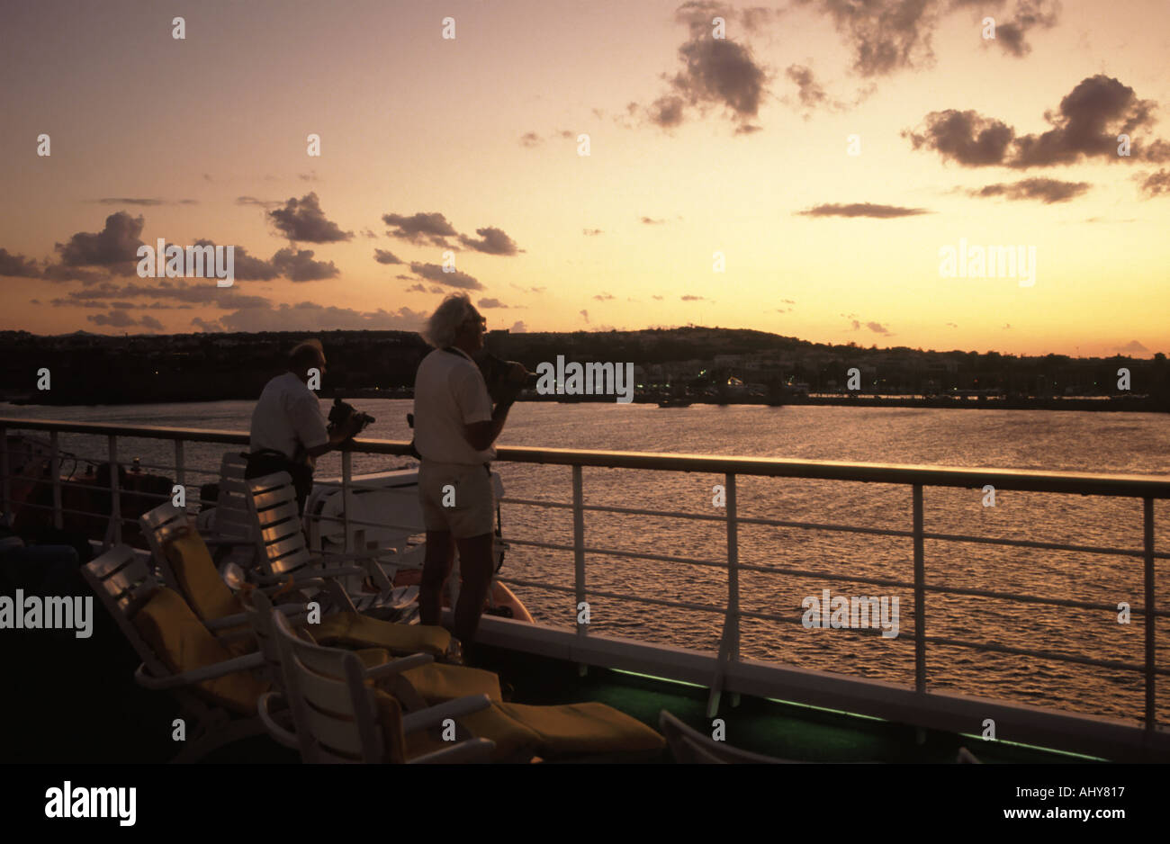 À bord d'un bateau de croisière avec des passagers photographiant le coucher du soleil au départ de l'île de Rhodes depuis le bateau de croisière Costa Marina Banque D'Images