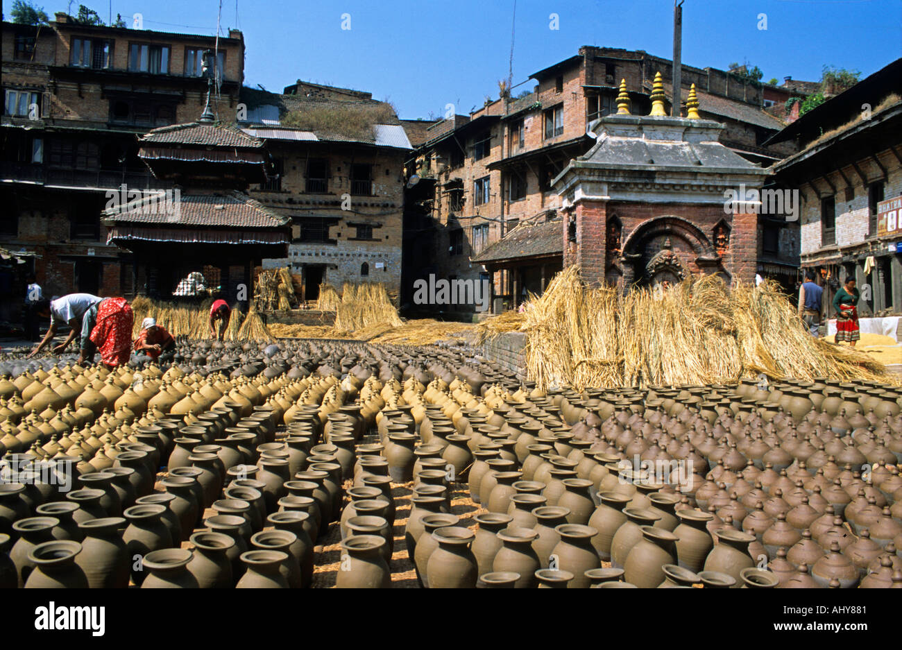 Place de poterie Bhaktapur Népal, où les pots traditionnels en argile sèchent au soleil au milieu de l'architecture historique en briques et des artisans locaux au travail. Banque D'Images