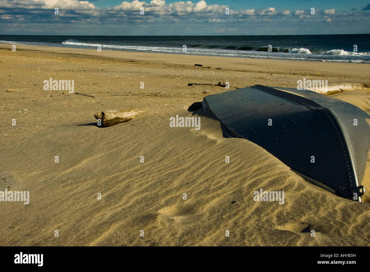 Une barque abandonnée se trouve à moitié enfoui sur une plage du New Jersey. Banque D'Images