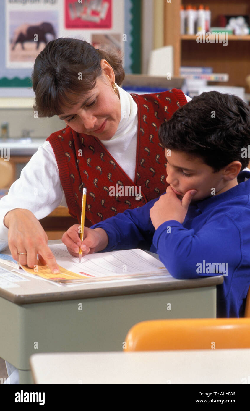 Caucasian teacher aider les élèves à l'école primaire verticale en classe Banque D'Images