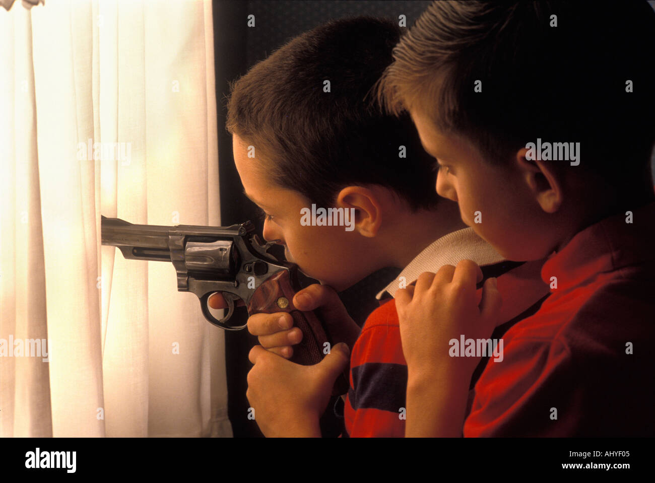 Young Caucasian boys jouant avec chargé revolver Magnum 357 Banque D'Images