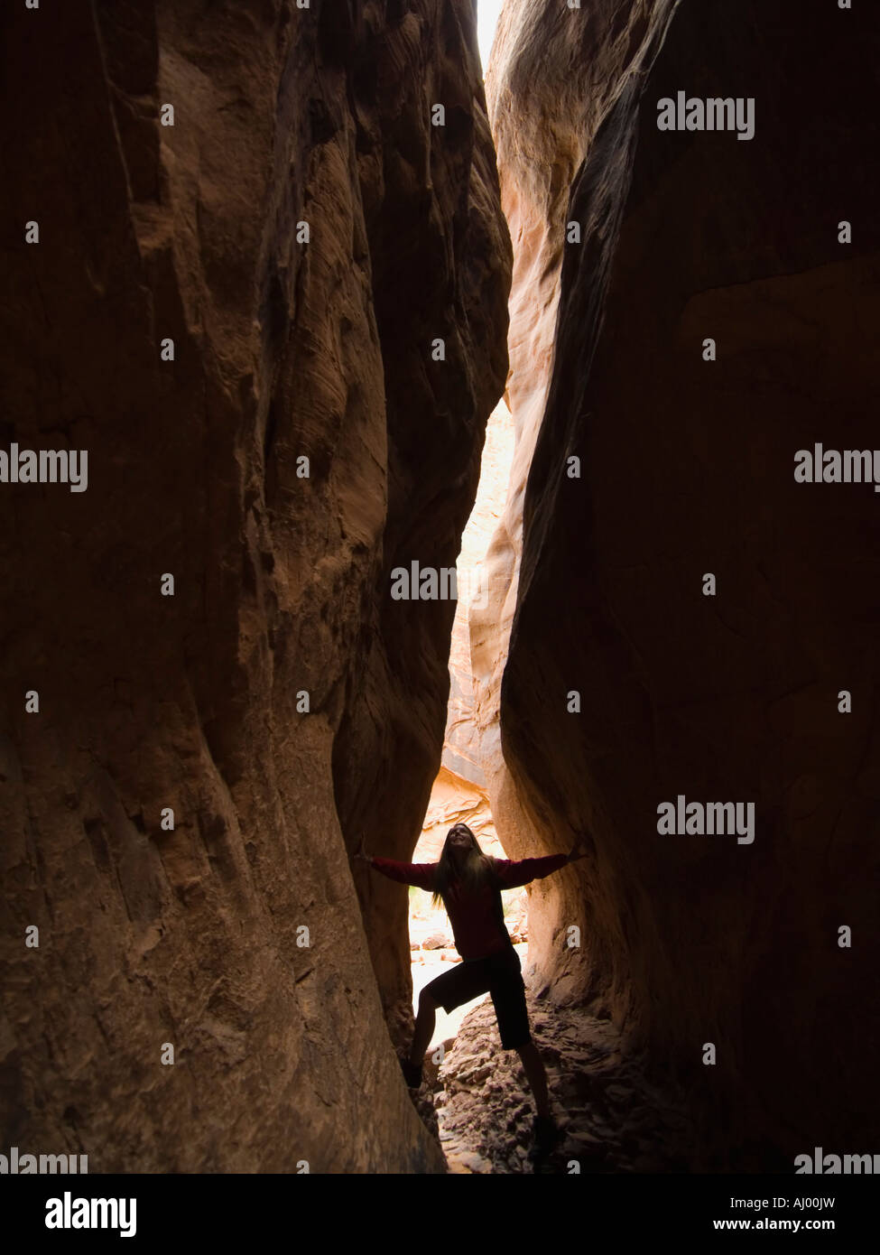 Woman looking up entre rock formations Banque D'Images