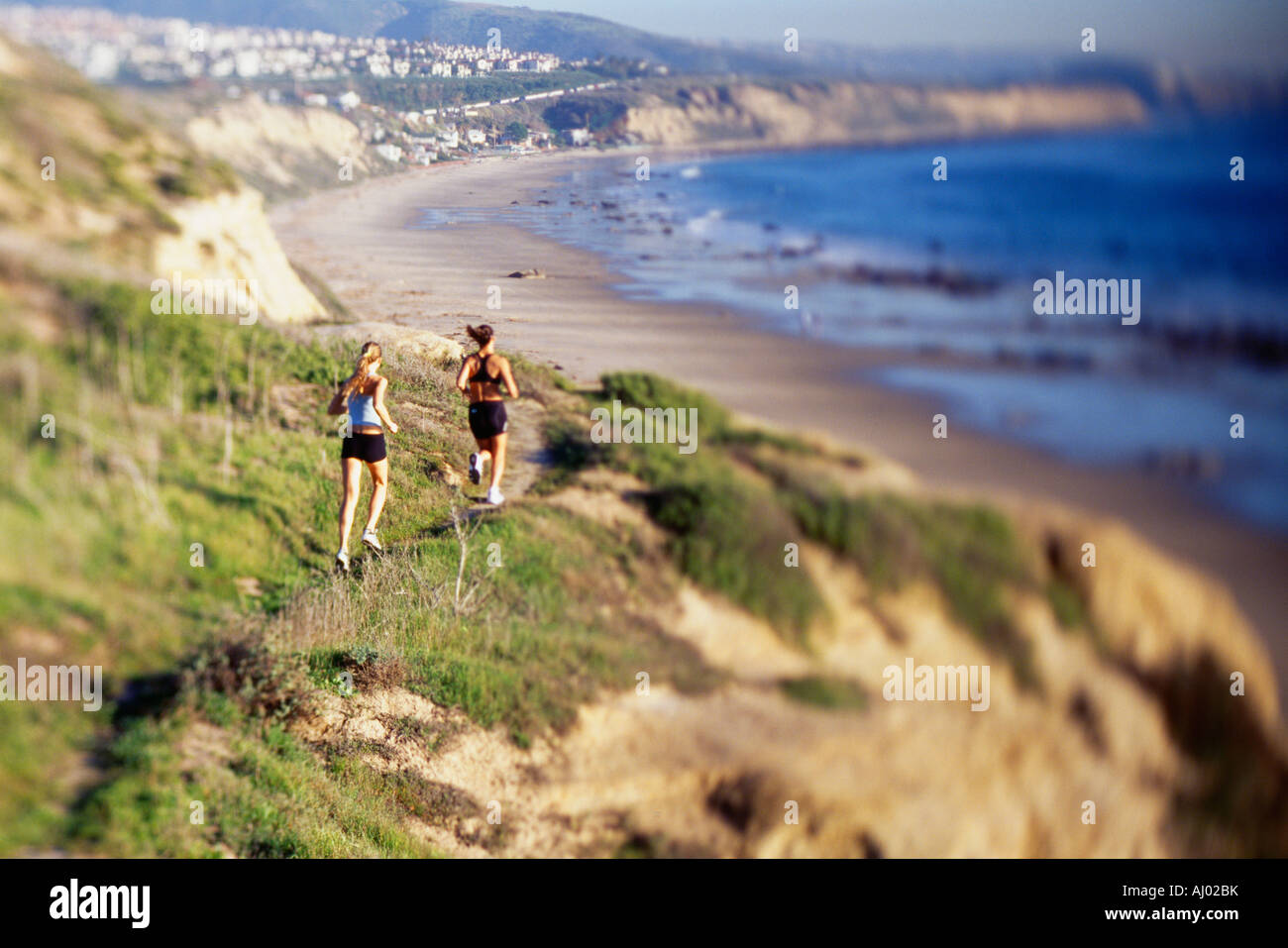 Women jogging sur l'eau le long de la falaise Banque D'Images