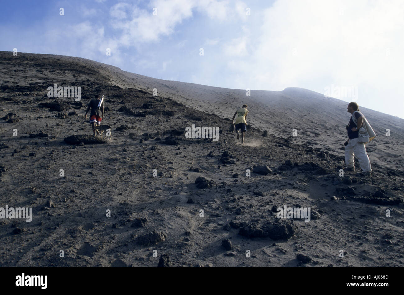 Avec deux guides touristiques locaux escalade le terrain en pente du volcan Yasur, île de Tanna, Vanuatu. Banque D'Images