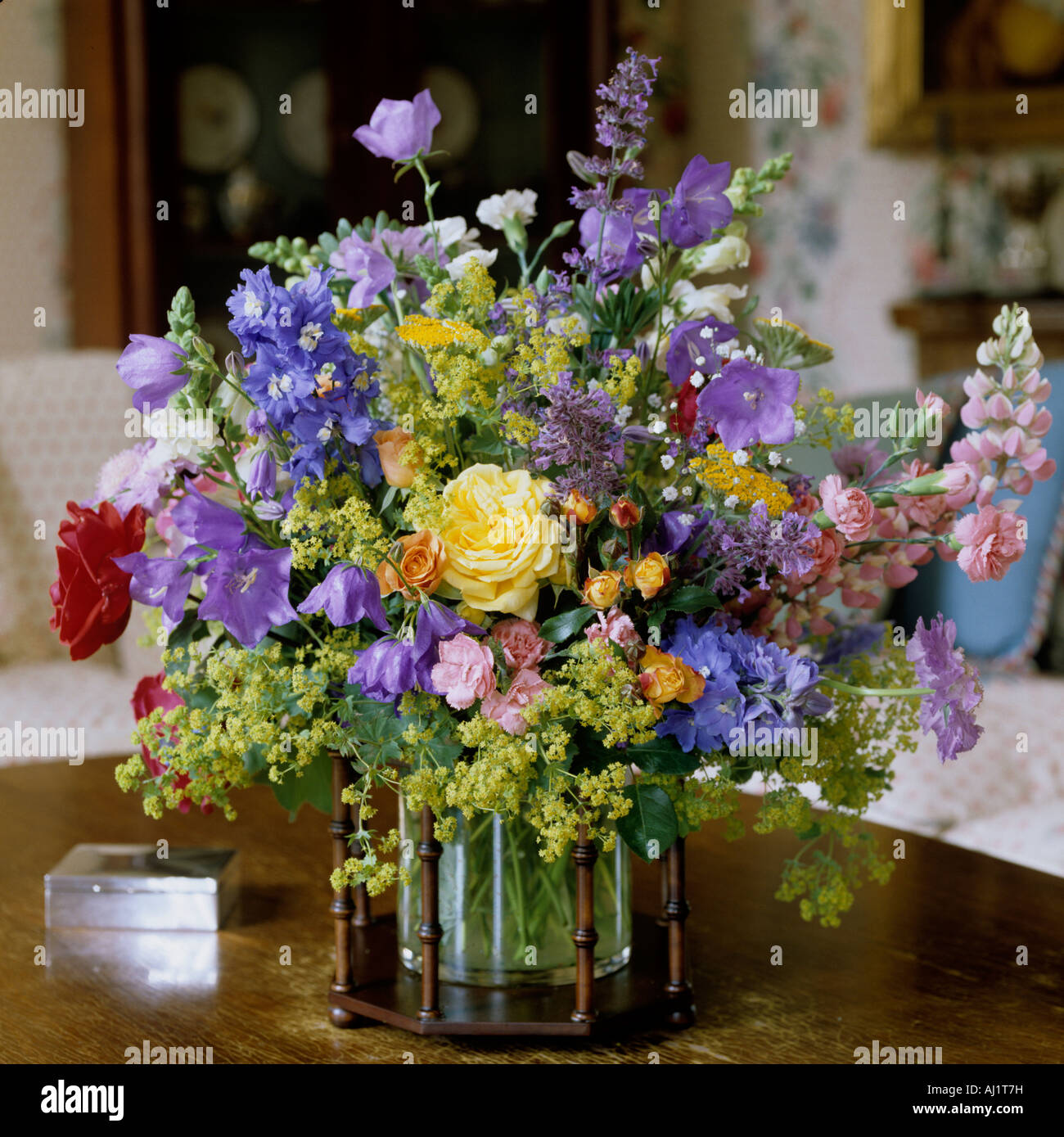 Arrangement de fleurs assorties en vase en verre avec cadre en bois. Banque D'Images