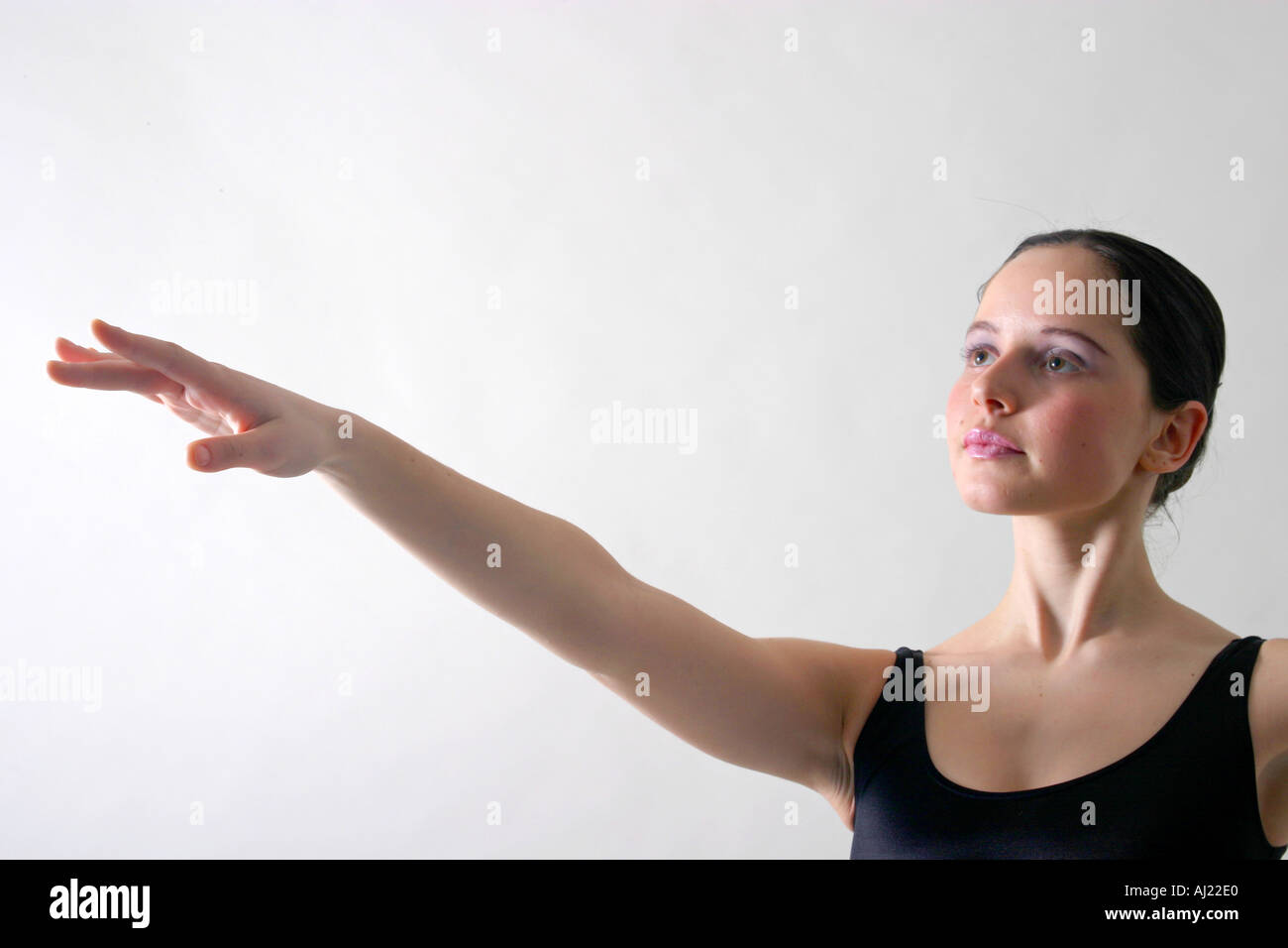 Jeune ballerine en noir de danseur avec bras droit étendu Banque D'Images