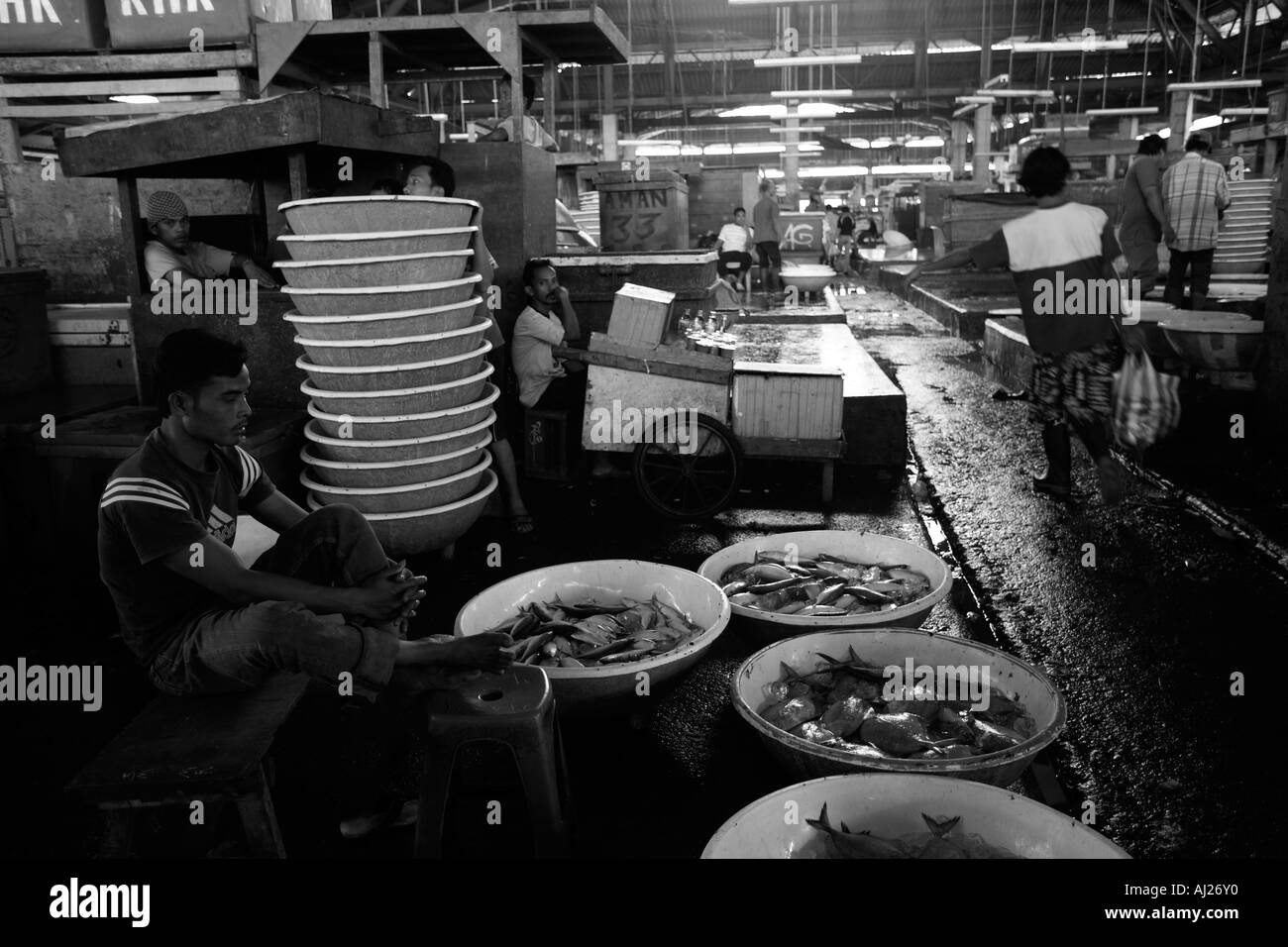 L'Indonésie Jakarta se trouve l'homme listelessly entouré par les poissons à l'intérieur de Muara Angke waterfront le long du marché Banque D'Images