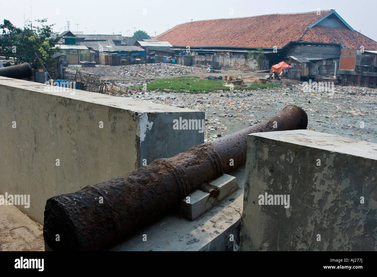 Old Dutch de canons à regarder ou Syahbandar Menara Lookout Tower donnent sur une rivière polluée d'ordures de Jakarta, Indonésie Banque D'Images