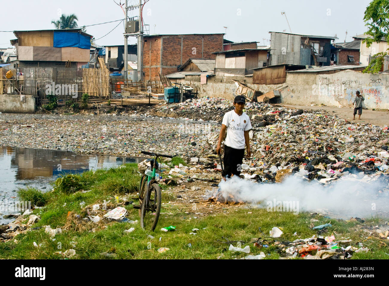 La combustion de déchets sur le tas d'ordures en bordure d'un quartier pauvre bidonville de Jakarta, Indonésie Banque D'Images