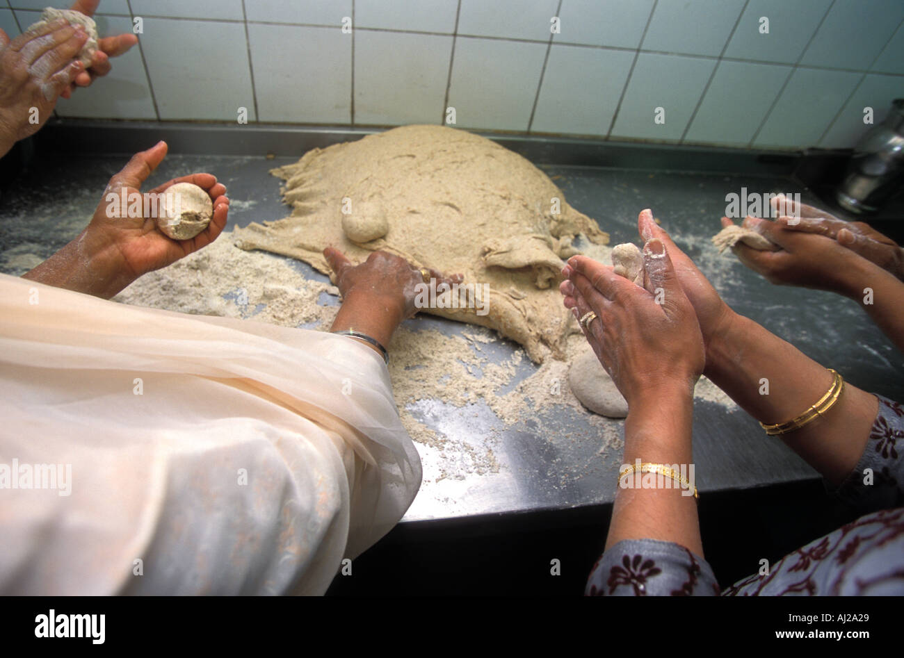 Les femmes bénévoles de la temple Sikh Gurdwara ou préparer chapattis pour la congrégation après la prière, Londres, Angleterre. Banque D'Images