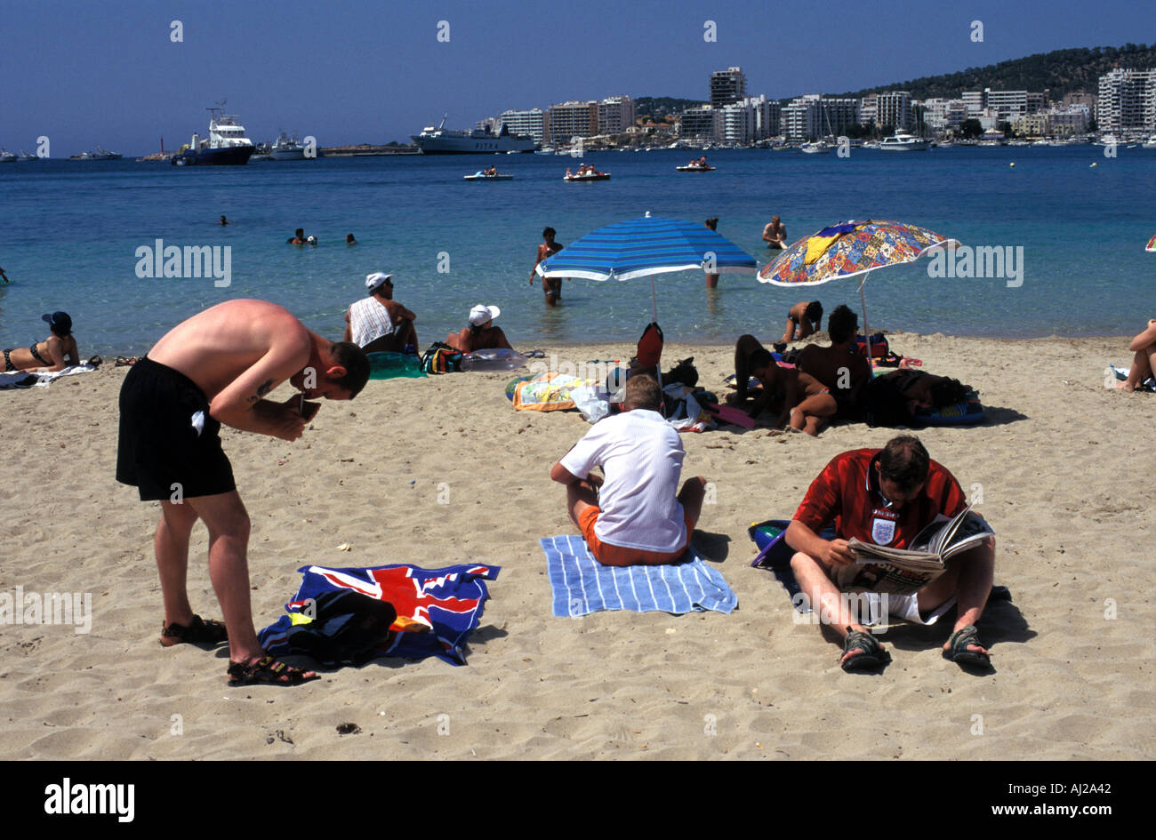 Les jeunes hommes anglais sur la plage de San Antonio, Ibiza, Espagne Banque D'Images