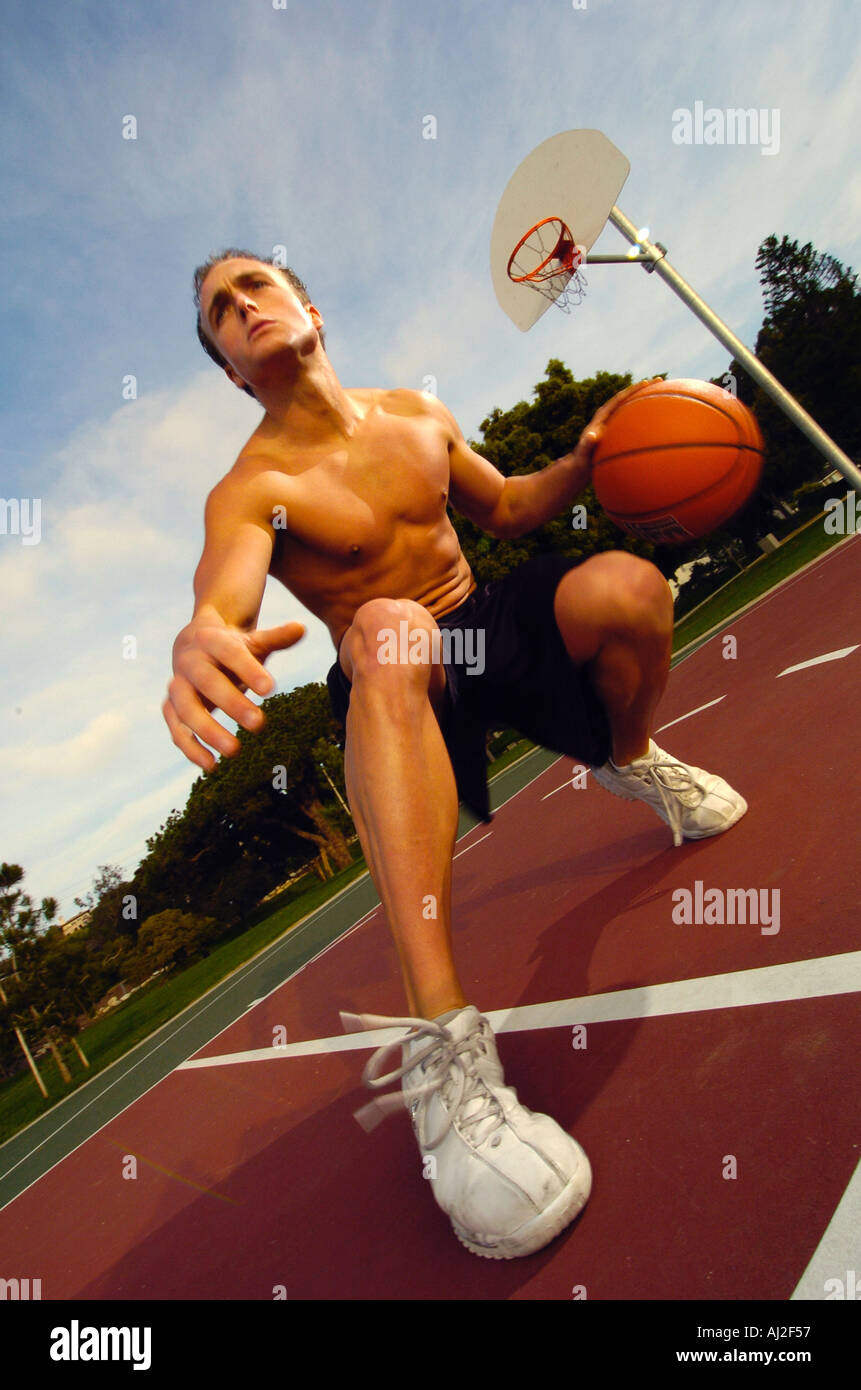 Un homme jouant au basket-ball dans un parc Banque D'Images