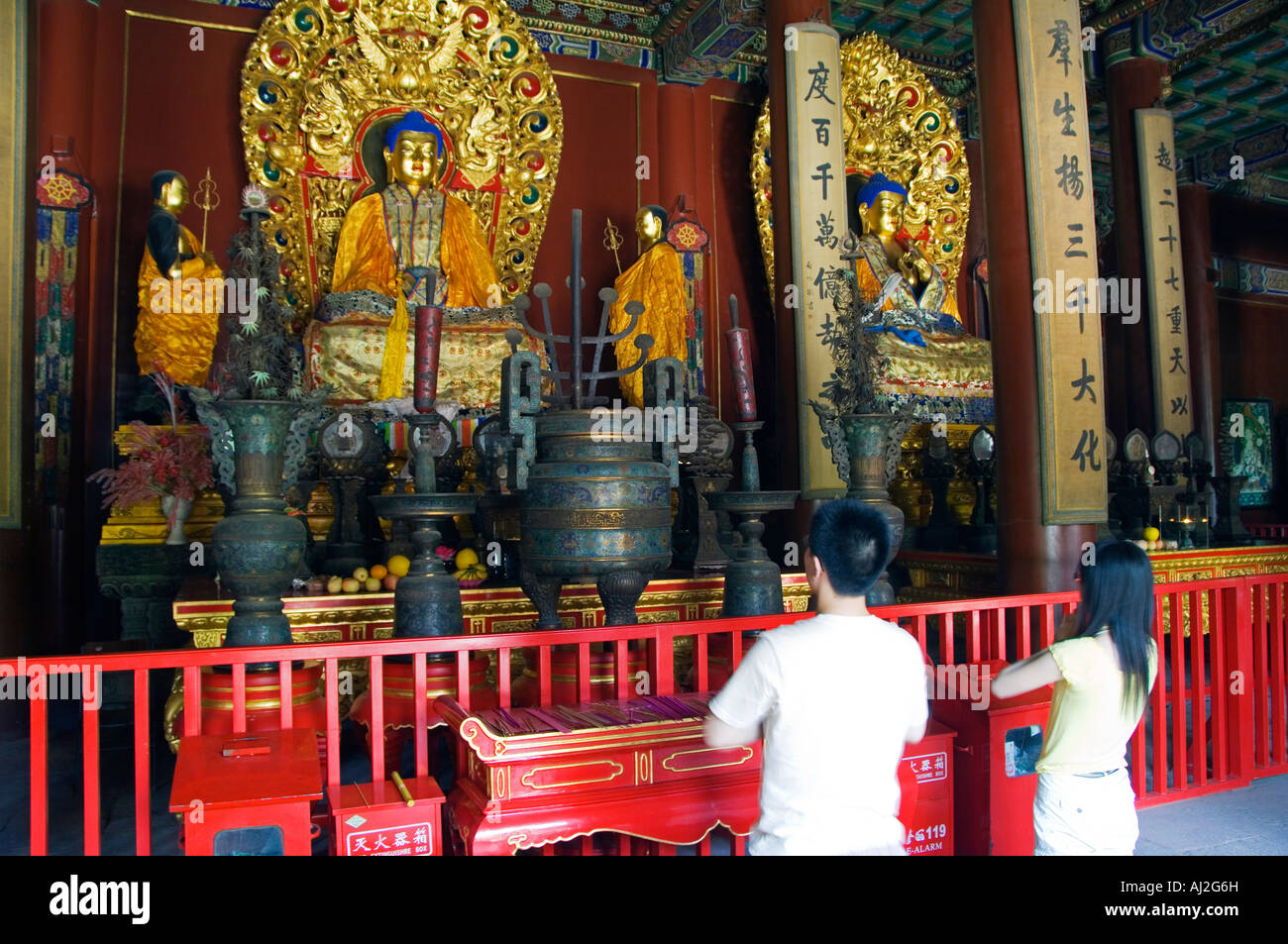 Les gens priant devant une statue de bouddha, Yonghe Gong, Lama Temple Bouddhiste Tibétain, Beijing, Chine Banque D'Images