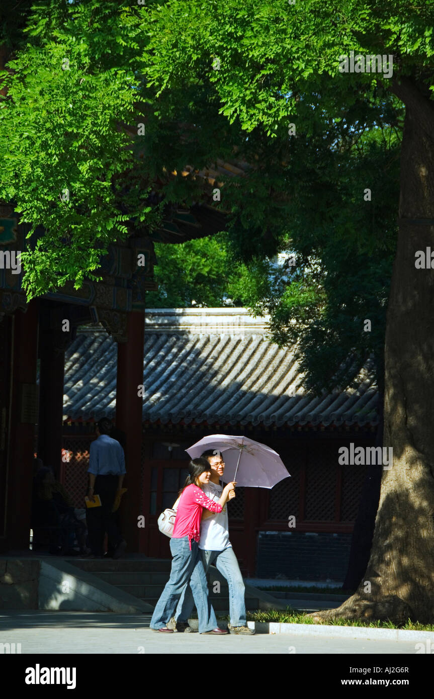 Un couple en train de marcher avec parasol, Yonghe Gong, Lama Temple Bouddhiste Tibétain, Beijing, Chine Banque D'Images