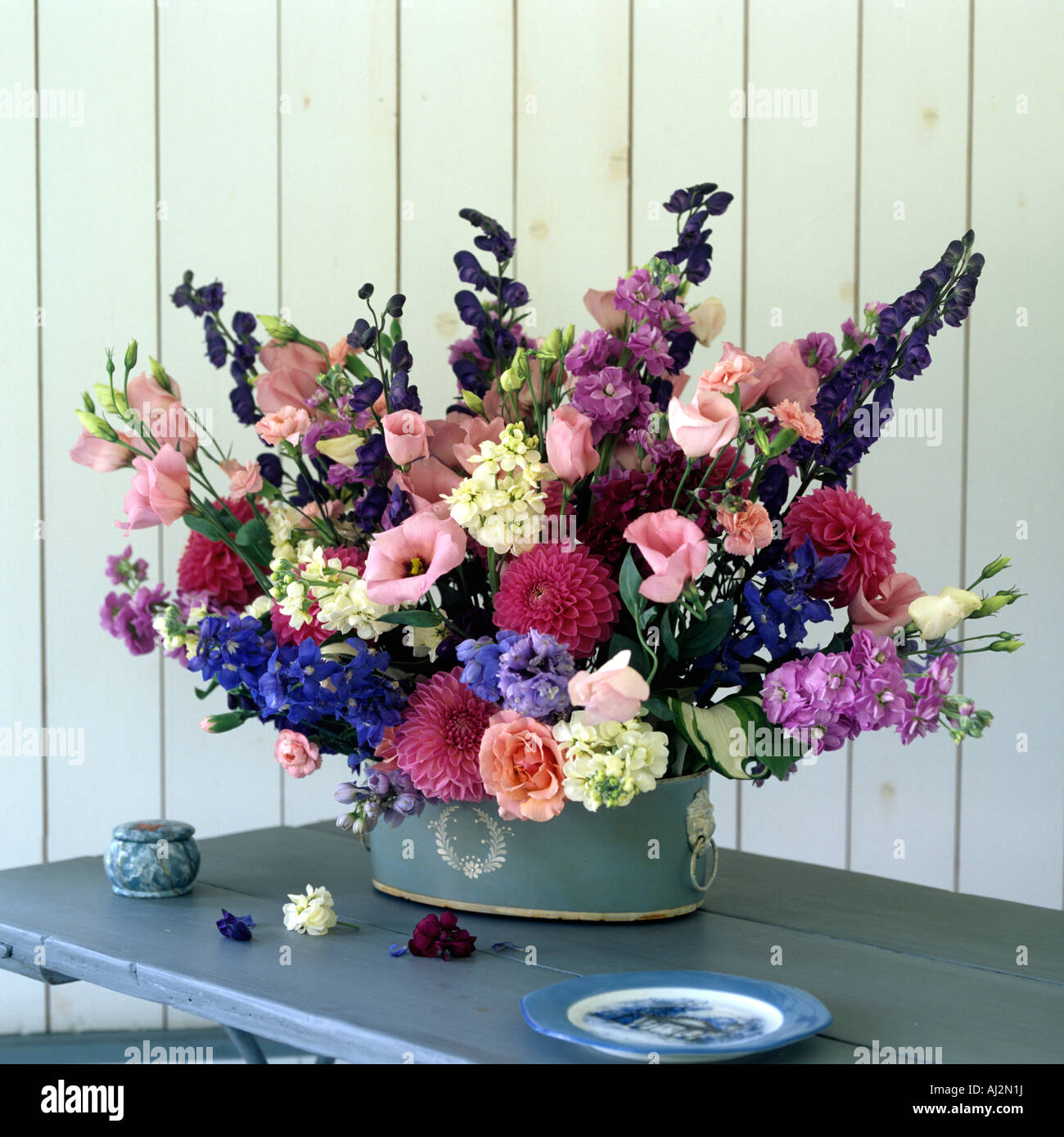 Arrangement de fleurs en pot bleu avec blanc cameo détails sur table en bois Banque D'Images