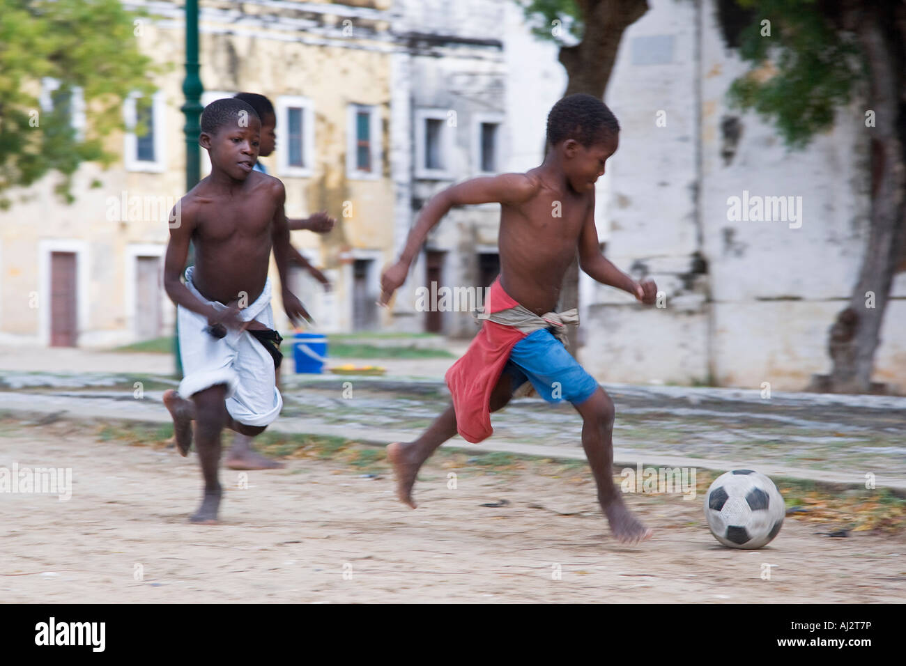 Les garçons jouent au football entre les maisons coloniales délabrées sur Ilha do Mozambique Banque D'Images