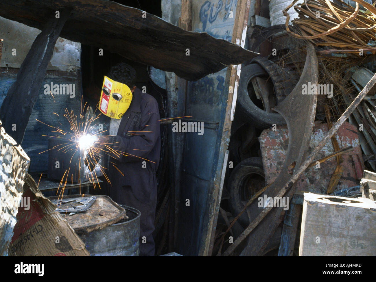 Un soudeur dans un atelier de recyclage dans l'Medebar même son casque de soudage est fabriqué à partir de matériaux recyclés Asmara Érythrée Banque D'Images