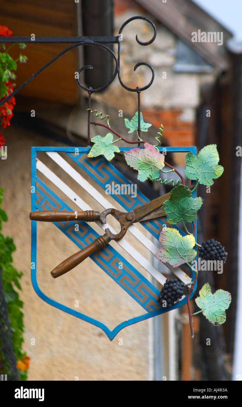 Une enseigne peinte en fer forgé qui illustre le thème de la production de vin et champagne : un secateur sur un manteau d'armes et d'une vigne avec des grappes de raisins, le village d'Hautvillers dans la vallée de la Marne, Champagne, Marne, Ardennes, France Banque D'Images