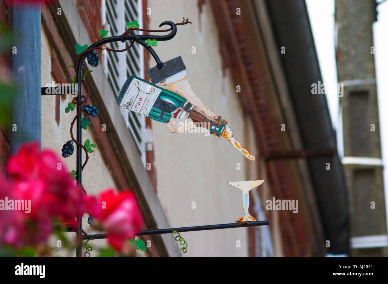 Une enseigne peinte en fer forgé qui illustre le thème de la production de vin et champagne : une main tenant une bouteille de vin pouring champagne dans une coupe de champagne, le village d'Hautvillers dans la vallée de la Marne, Champagne, Marne, Ardennes, France Banque D'Images