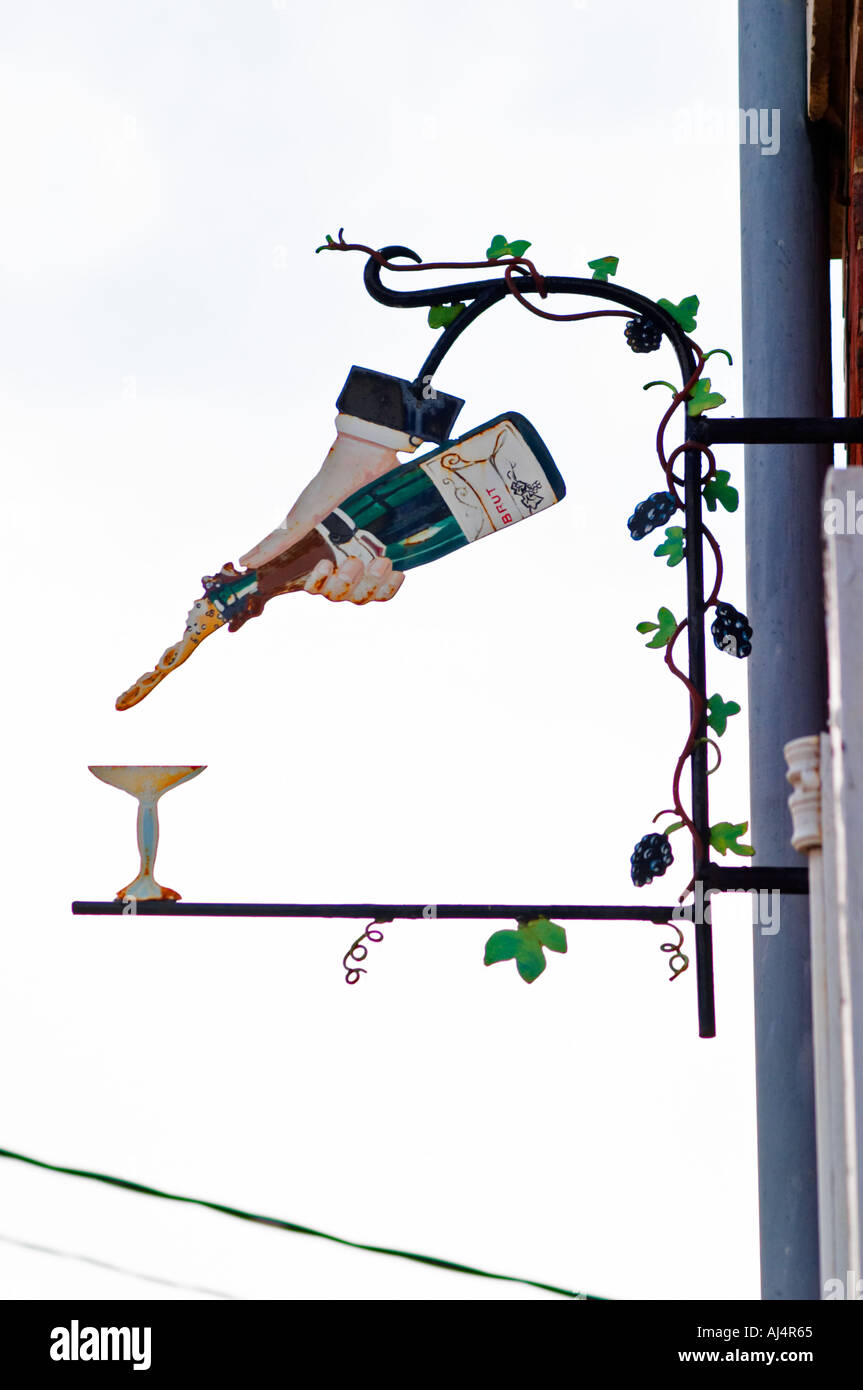 Une enseigne peinte en fer forgé qui illustre le thème de la production de vin et champagne : une main tenant une bouteille de vin pouring champagne dans une coupe de champagne, le village d'Hautvillers dans la vallée de la Marne, Champagne, Marne, Ardennes, France Banque D'Images