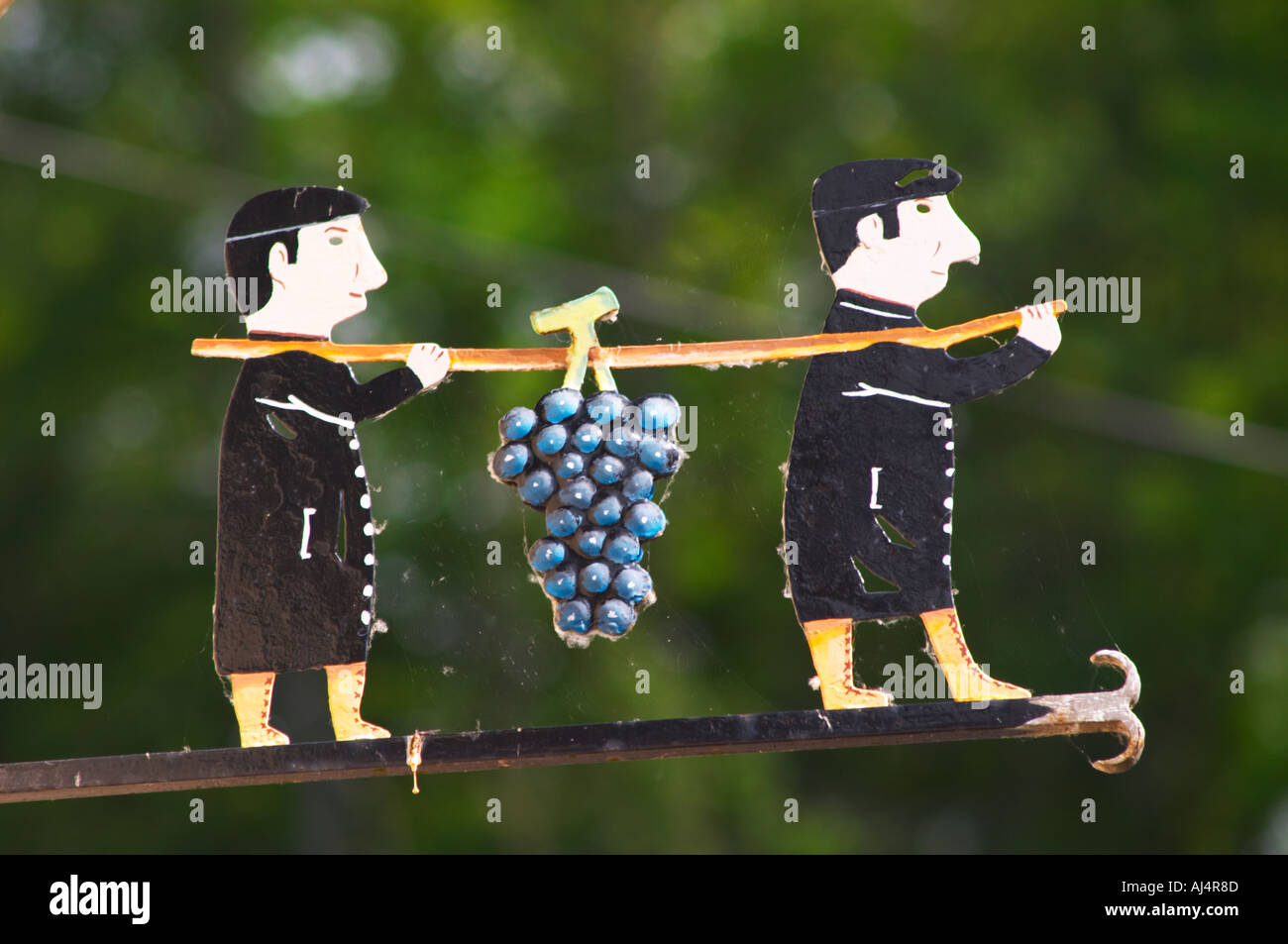 Une enseigne peinte en fer forgé qui illustre le thème de la production de vin et champagne : deux hommes en noir tenant une perche sur le Banque D'Images