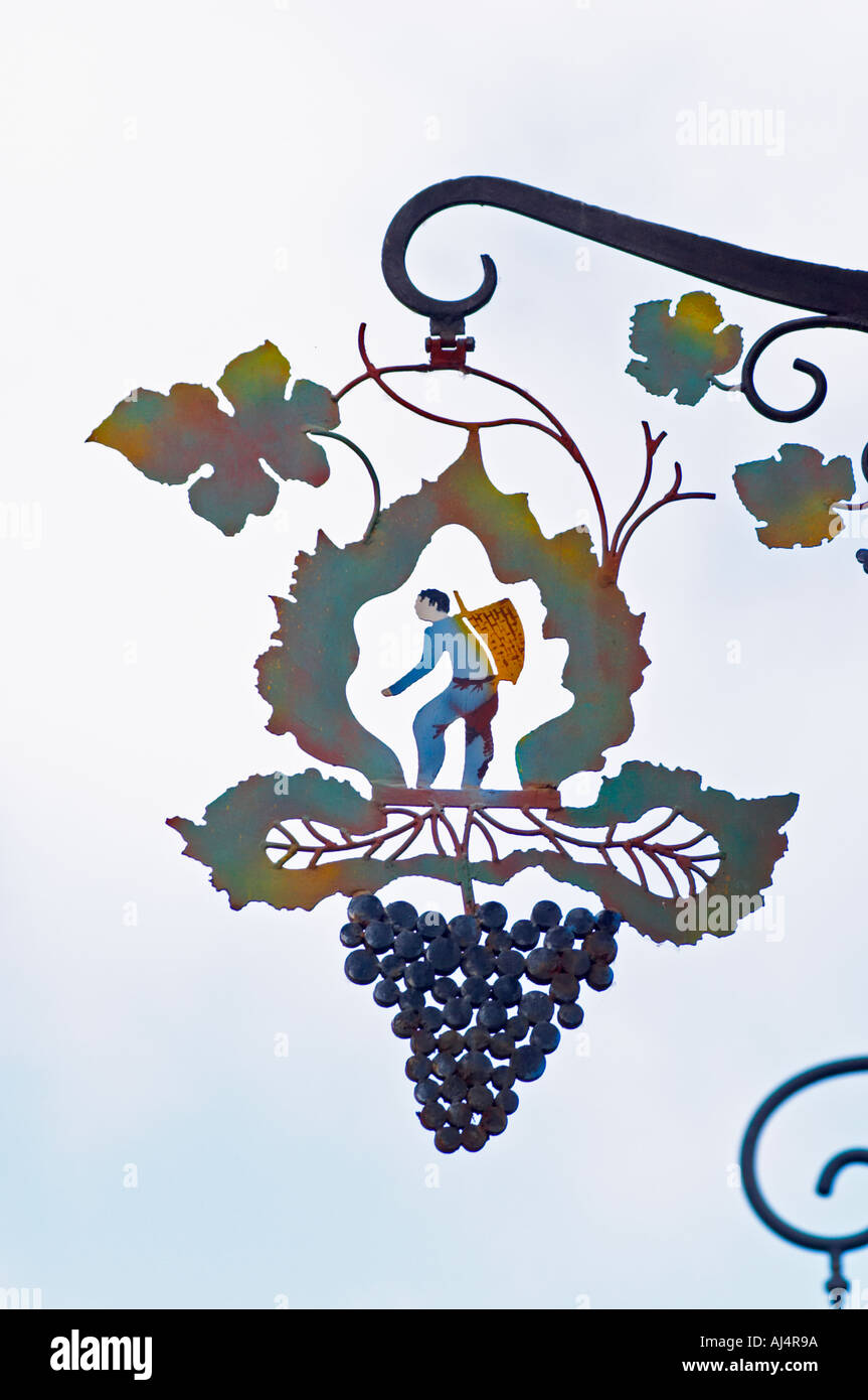 Une enseigne peinte en fer forgé qui illustre le thème de la production de vin et champagne : une feuille de vigne stylisée, une grappe de raisins et d'un homme transportant un panier de récolte (hotte) sur le dos de recueillir le raisin, le village d'Hautvillers dans la vallée de la Marne, Champagne, Marne, Ardennes, France Banque D'Images