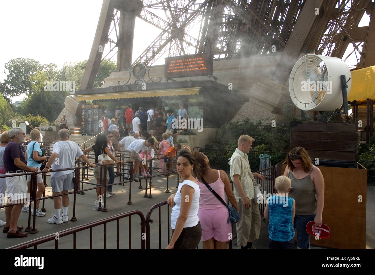 En attendant les touristes à visiter la Tour Eiffel sous le brouillard de pulvérisation au cours de l'été, canicule, Paris, France Banque D'Images