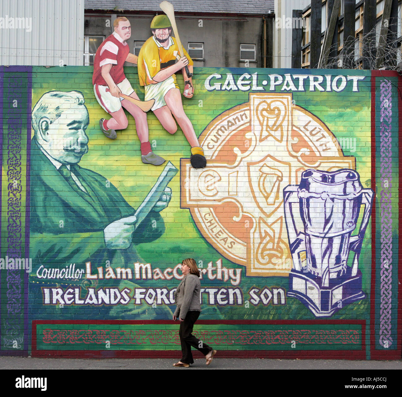 Une femme passe devant une peinture murale sur la partie inférieure de Falls Road à l'ouest de l'Irlande du Nord Belfast 19 Oct 2007 Photo Paul McErlane Banque D'Images