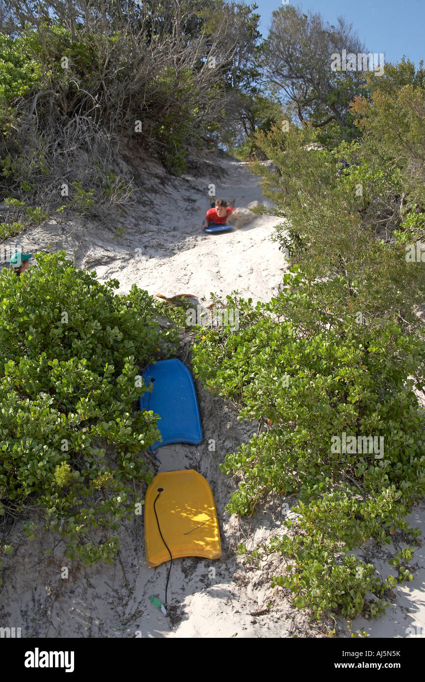 Jeune homme ou garçon surf de sable s'abattre une dune à Yacaaba près de Port Stephens de Hawks Nest NSW Australie Nouvelle-Galles du Sud CC 2A Banque D'Images