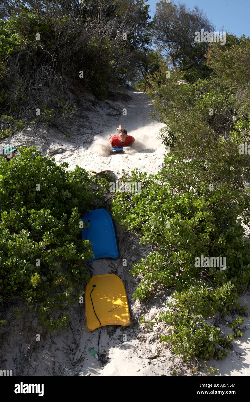 Jeune homme ou garçon surf de sable s'abattre une dune à Yacaaba près de Port Stephens de Hawks Nest NSW Australie Nouvelle-Galles du Sud CC 2A Banque D'Images