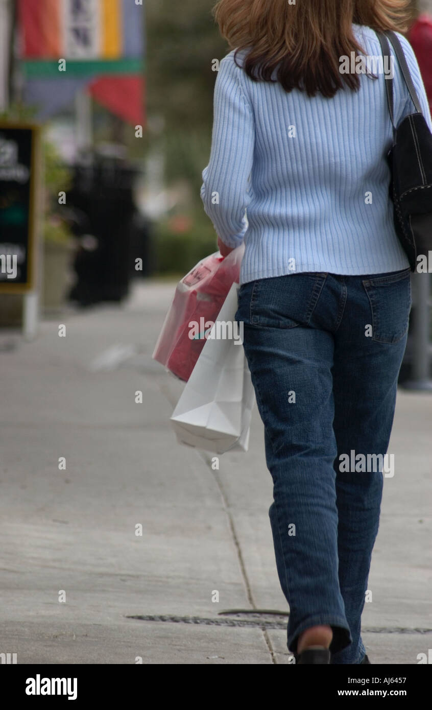 Porter femme pull bleu Walking Down Street Carrying Shopping Bag USA Photo  Stock - Alamy