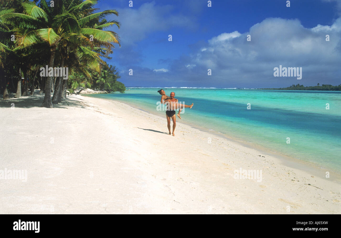 Homme et femme s'amusant le long de côte sablonneuse de l'île d'Aitutaki aux Îles Cook dans le Pacifique Sud Banque D'Images