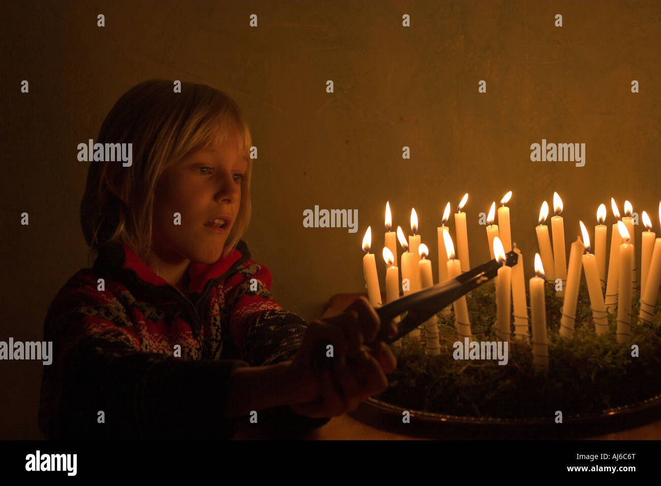 Un handikrafting enfant guirlande de mousse et paille et fixé sur la flamme des bougies Banque D'Images