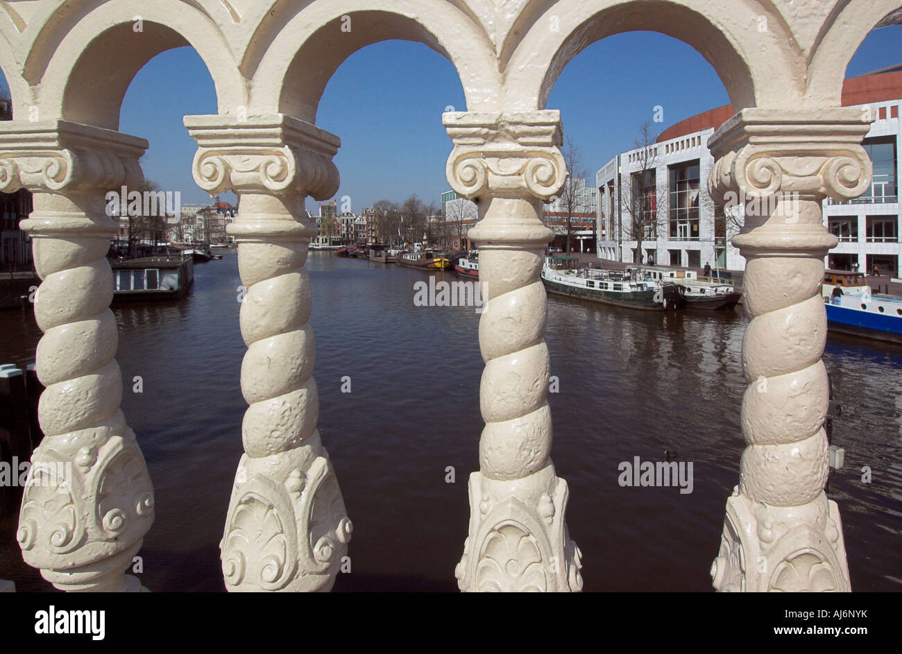 Une vue le long de la rivière Amstel à Amsterdam vu à travers les barreaux de la Blauwe Brug bridge Banque D'Images
