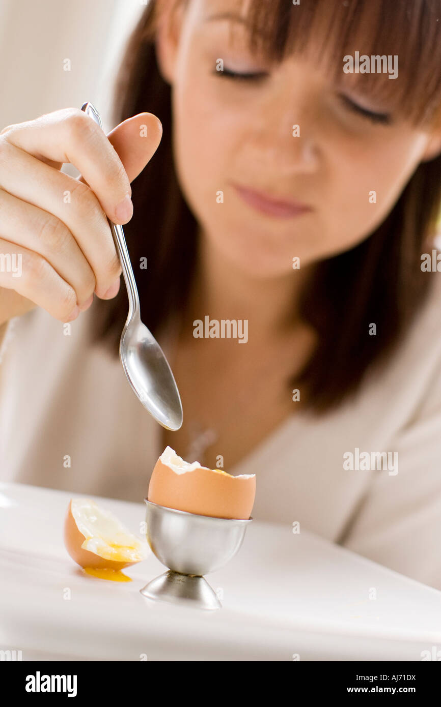 Woman eating boiled egg Banque D'Images