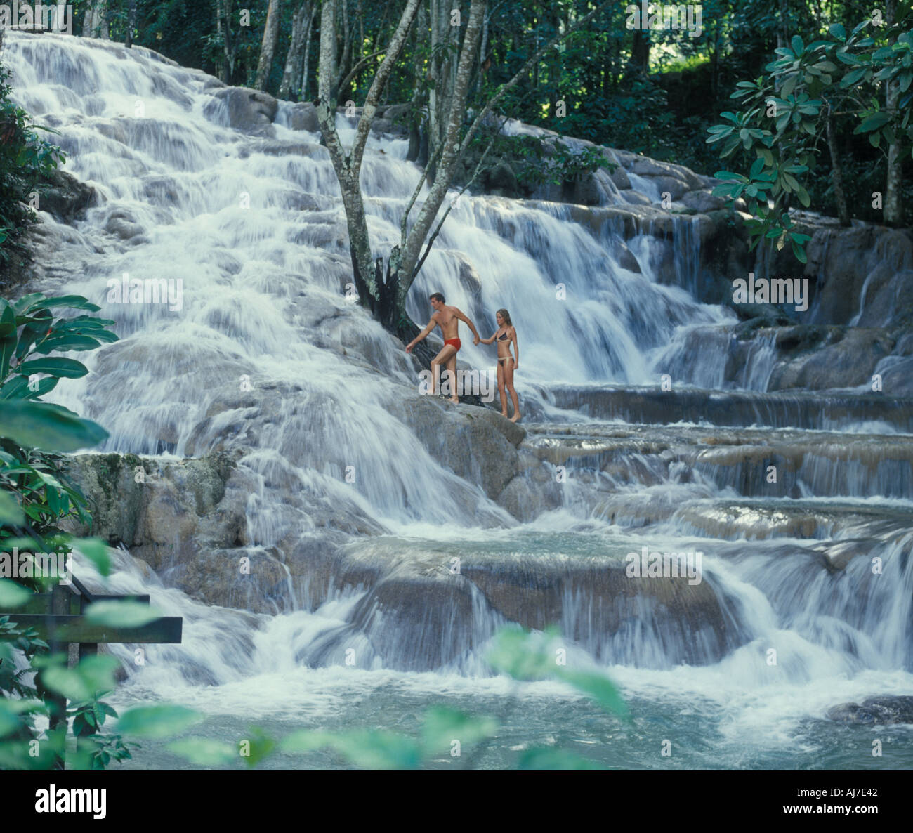 Couple climbing sur Dunn s River Falls à Ochos Rios en Jamaïque Banque D'Images