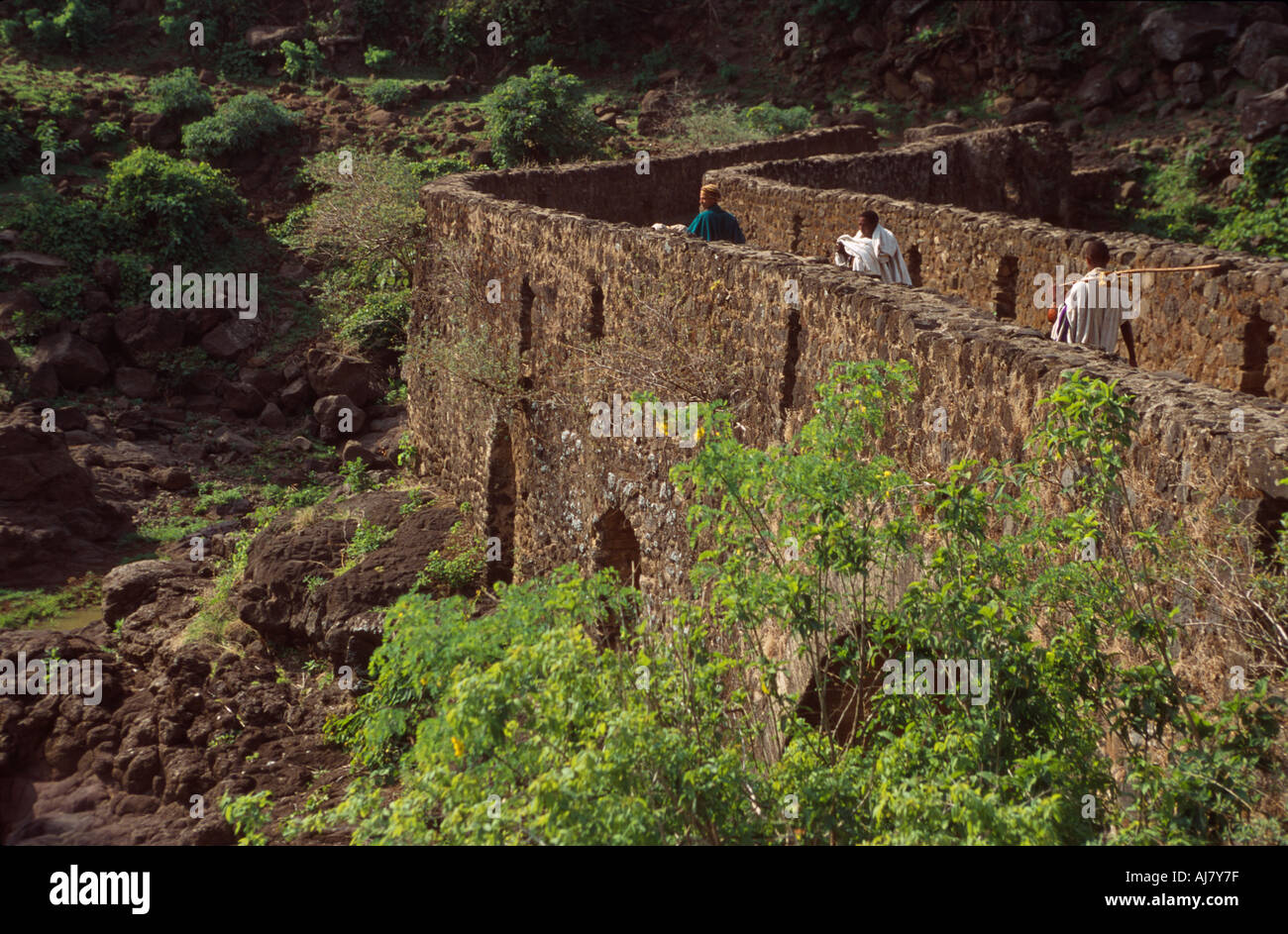 Les gens en vêtements traditionnels traversant le pont portugais près du Tis Issat (chutes du Nil bleu), Bahar Dar (Ethiopie) Banque D'Images