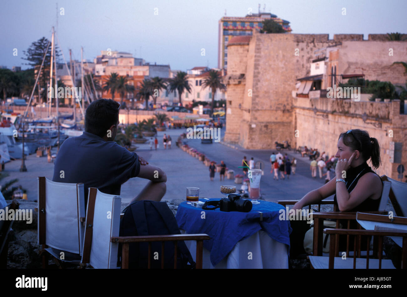 Couple assis dans un café de la chaussée de la vieille ville de Alghero Gallura Sardaigne Italie Banque D'Images