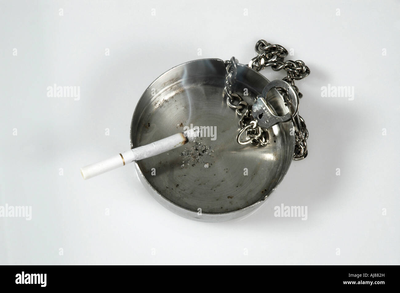 Cendrier Cigarette et handcusffs un concept montrant la dépendance des personnes à la cigarette et de la nicotine Banque D'Images