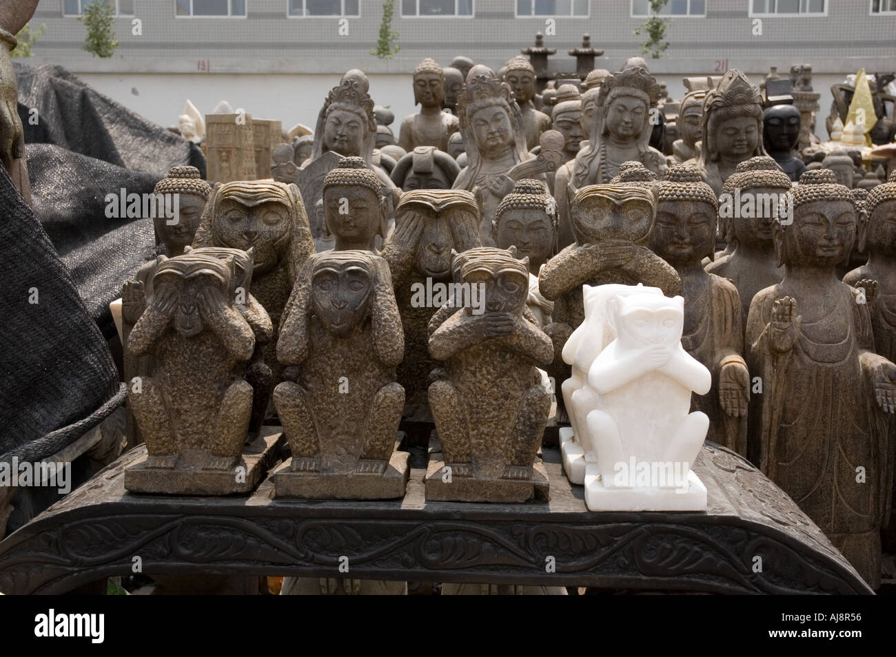 Trois Singes de la sagesse et de statuettes de Bouddha au marché la saleté de Panjiayuan Beijing, Chine Banque D'Images