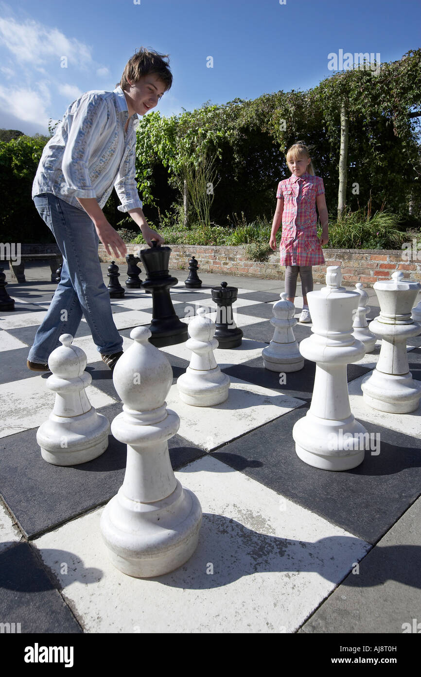 Fille de 9 ans et garçon de 15 ans jouer aux échecs sur un jeu géant dans  le parc de Burton Agnes Hall East Yorkshire UK Photo Stock - Alamy