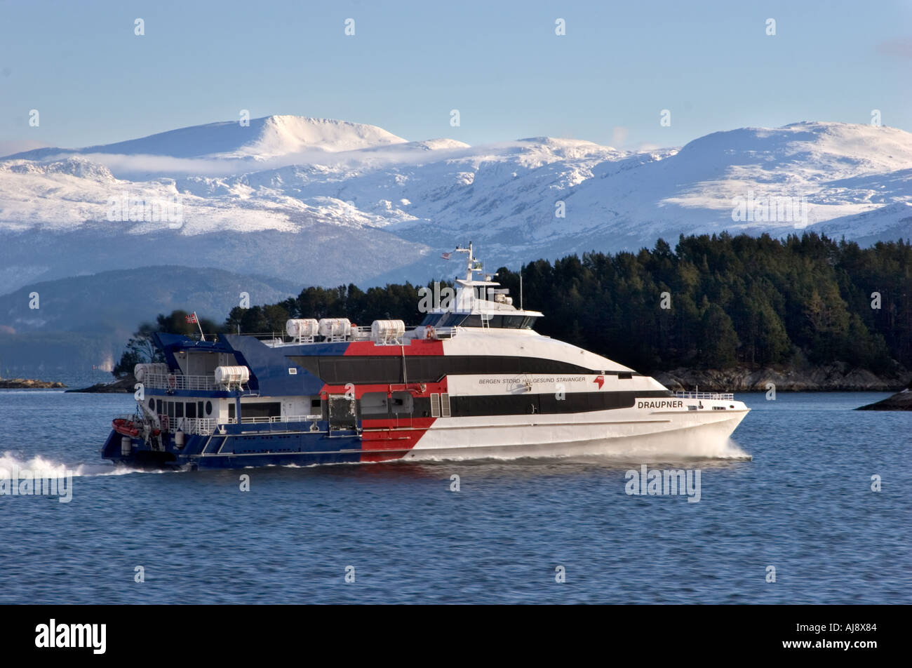 Fast-ferry Leirvik harbour une belle journée d'hiver, La Spezia, la Norvège. Montagnes couvertes de neige de Hardanger en arrière-plan. Banque D'Images