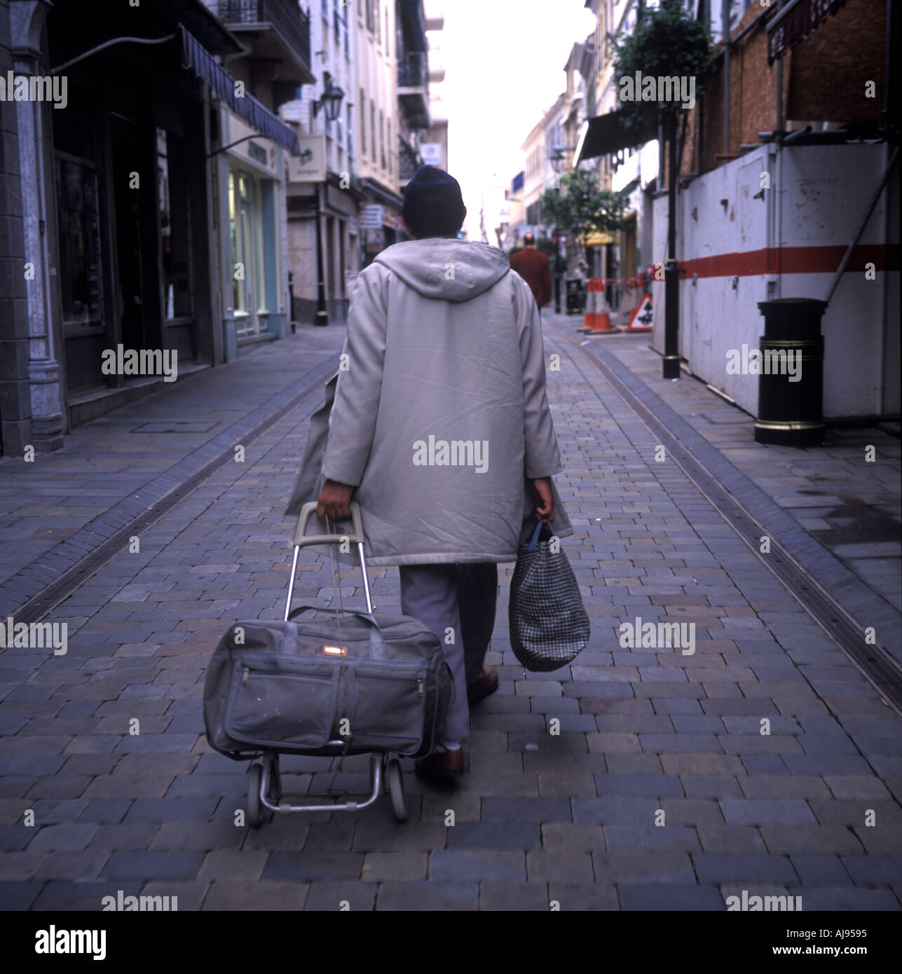 Un travailleur marocain marcher sur la rue principale avec ses affaires, Gibraltar.2002. Banque D'Images