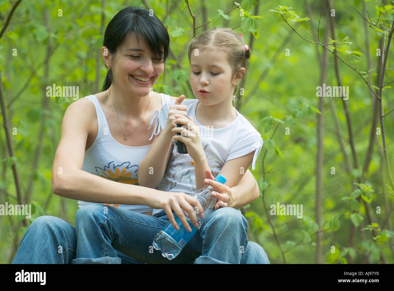Mother and Daughter sitting together in forest Banque D'Images