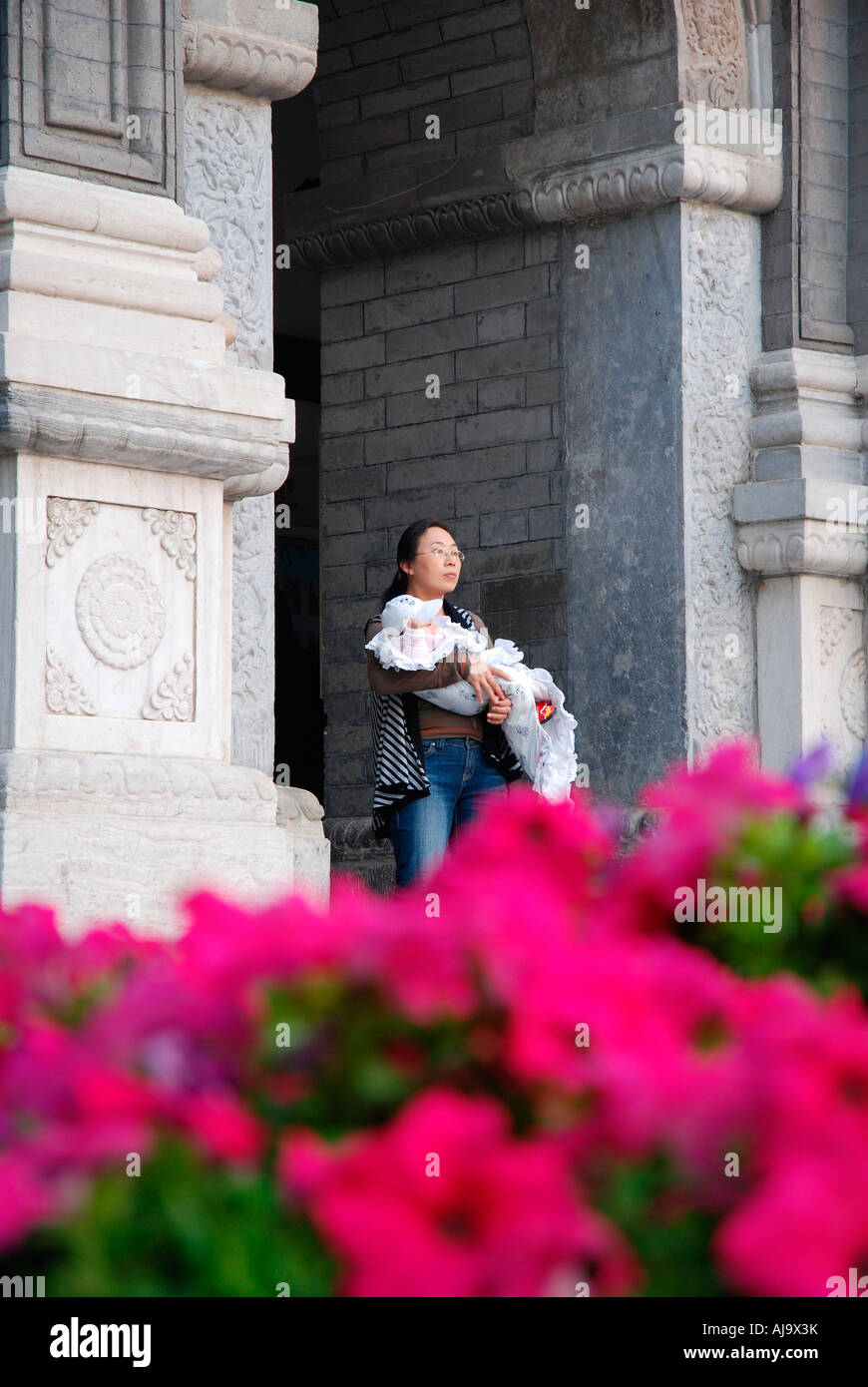 Chinese woman holding baby à l'extérieur de l'église St Joseph's Beijing Banque D'Images