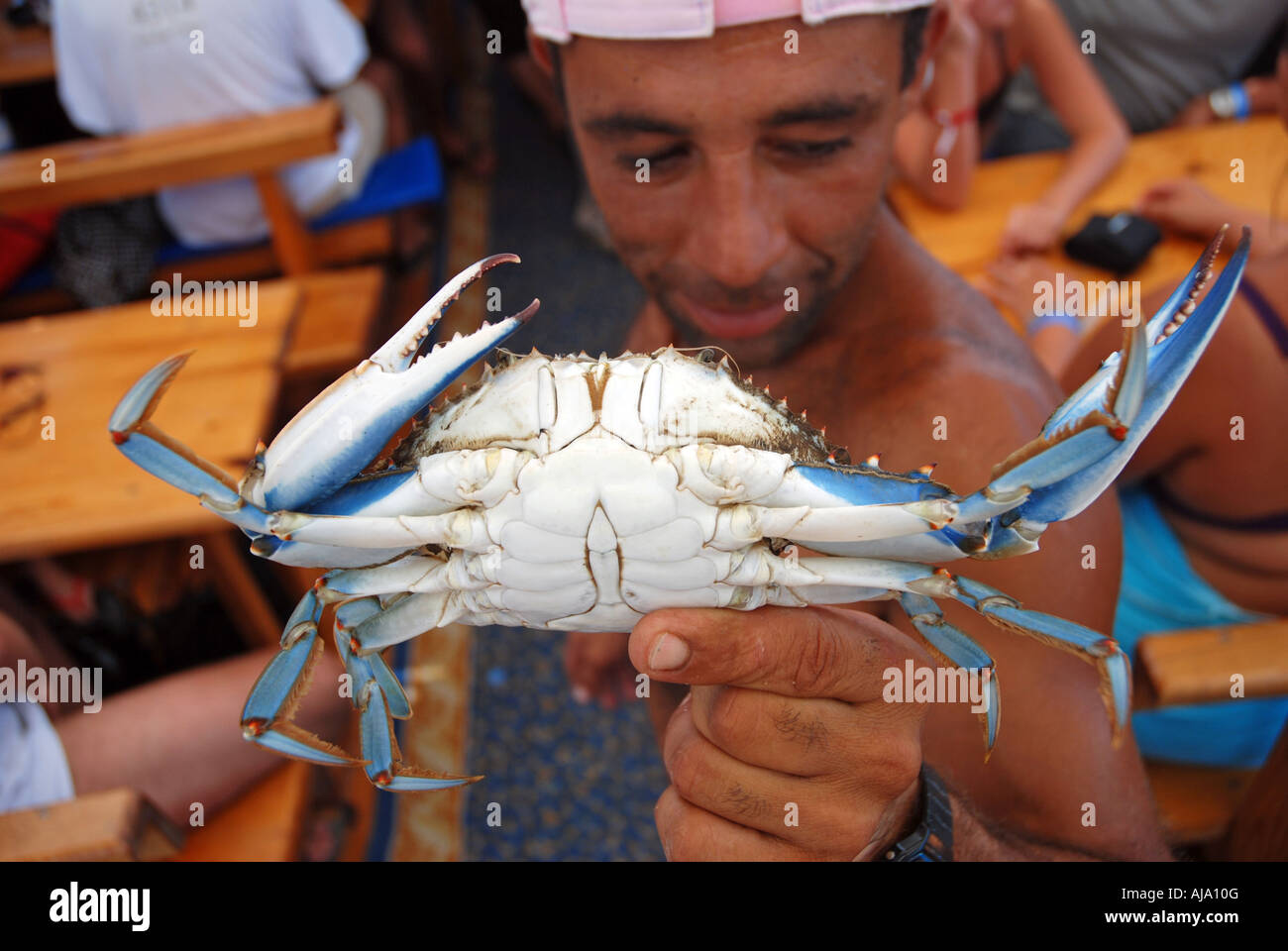 Le pêcheur local montrant un crabe bleu, essayez de les encourager à acheter un plat fait de lui sur le bateau de touristes rivière Dalyan, Turquie Banque D'Images