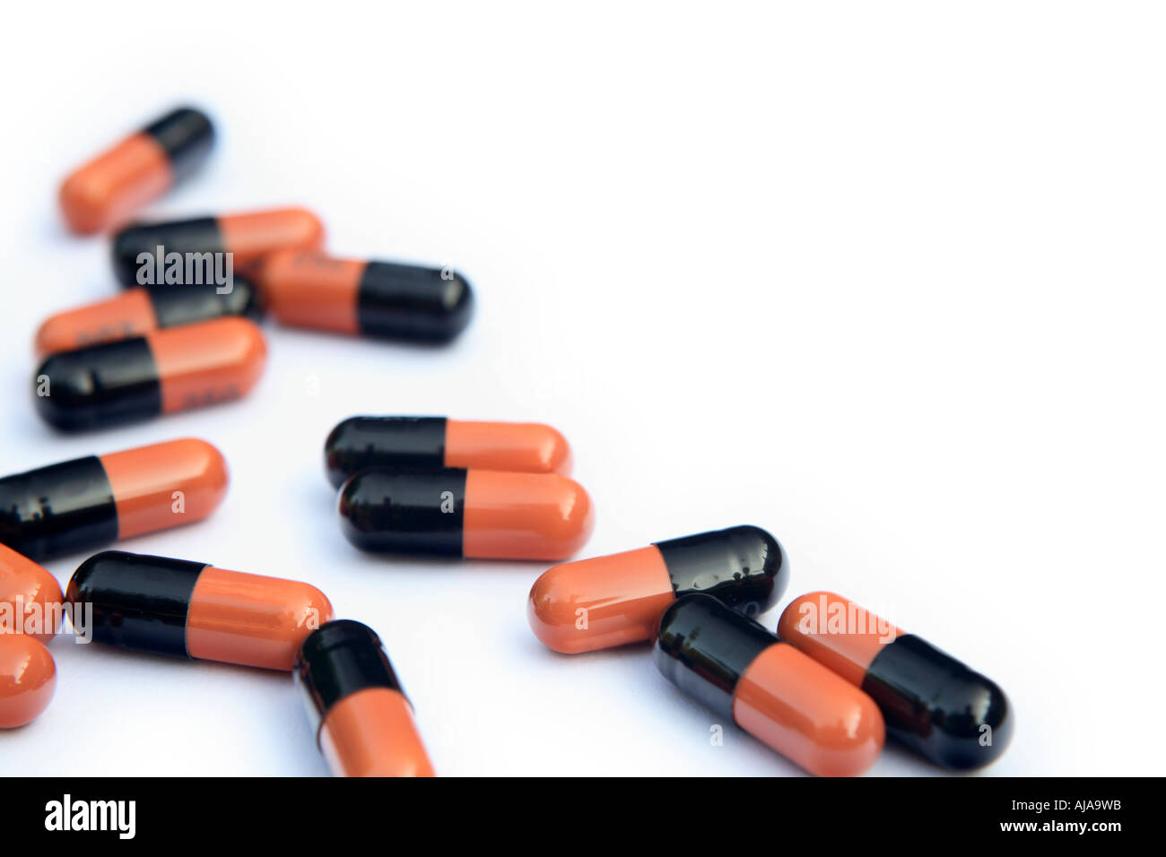 Capsules en noir et orange sur fond blanc Banque D'Images